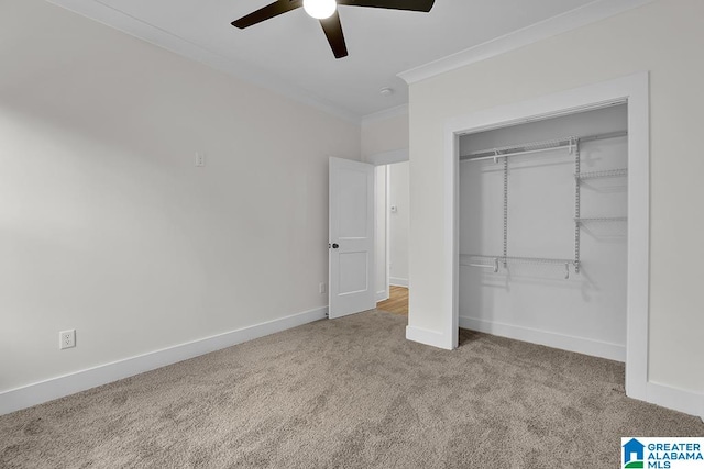 unfurnished bedroom with ceiling fan, a closet, crown molding, and light carpet