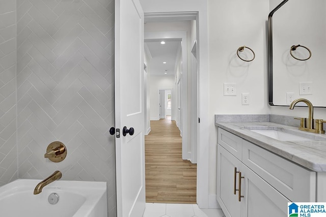 bathroom featuring tile patterned flooring, shower / bathing tub combination, tile walls, and vanity