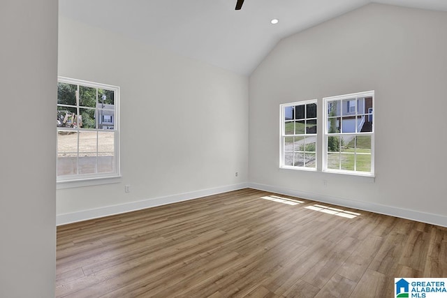 unfurnished room featuring light wood-type flooring, plenty of natural light, and lofted ceiling