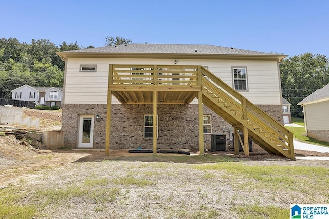 rear view of property with brick siding, central AC, a wooden deck, and stairs