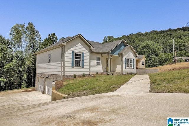 ranch-style home featuring a garage, driveway, and a front lawn