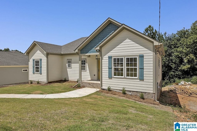 view of front facade featuring a front lawn and roof with shingles