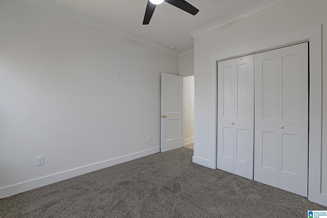 unfurnished bedroom featuring ornamental molding, a closet, ceiling fan, and dark colored carpet