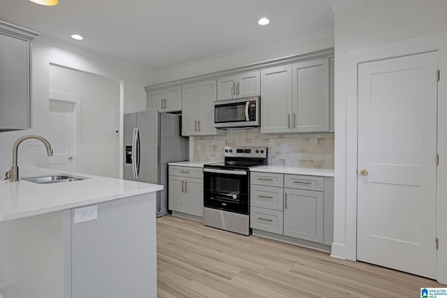 kitchen featuring sink, stainless steel appliances, light stone counters, light hardwood / wood-style floors, and decorative backsplash