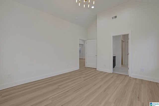 unfurnished bedroom with ensuite bath, light hardwood / wood-style floors, and high vaulted ceiling