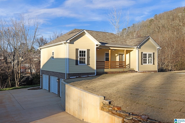 ranch-style home featuring a porch, a garage, and a front yard