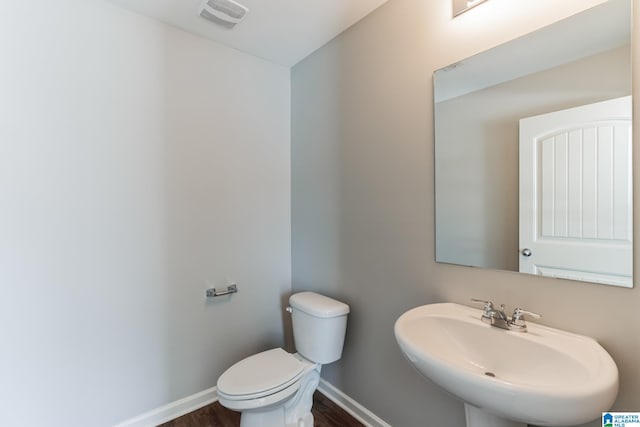 bathroom with hardwood / wood-style floors, sink, and toilet