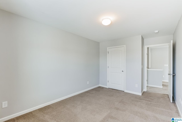 unfurnished bedroom with a closet and light carpet