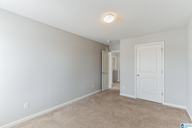 unfurnished bedroom with a closet and light colored carpet