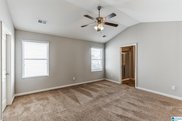 unfurnished room with ceiling fan, vaulted ceiling, and light colored carpet