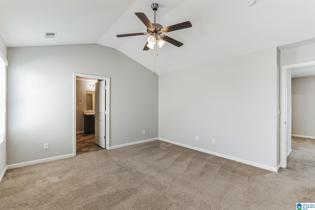 unfurnished bedroom featuring ceiling fan, lofted ceiling, connected bathroom, and light carpet