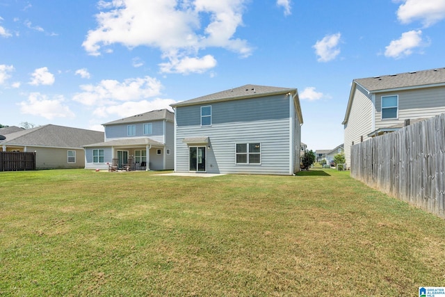 back of house with a patio and a lawn