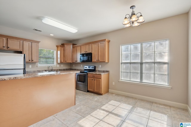 kitchen with appliances with stainless steel finishes, light tile patterned flooring, an inviting chandelier, and sink