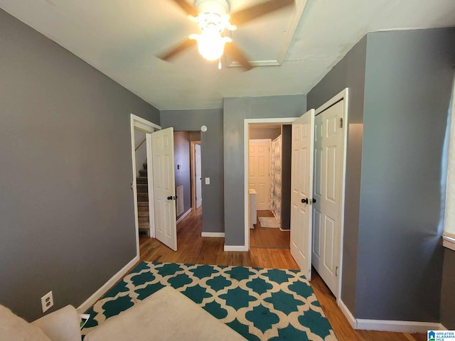 bedroom featuring ceiling fan, hardwood / wood-style flooring, and connected bathroom