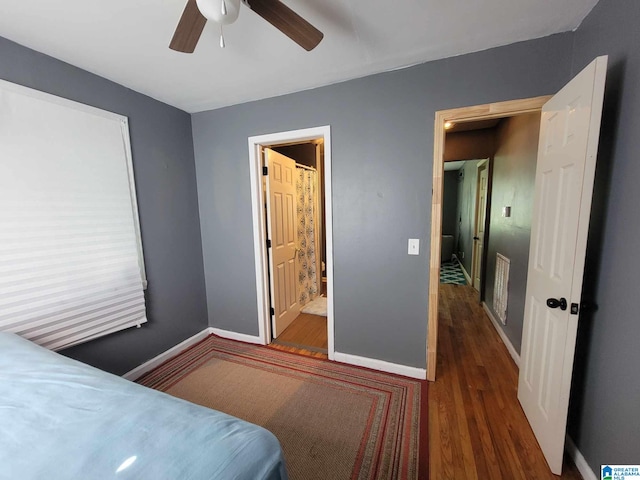 bedroom with ceiling fan, dark wood-type flooring, and ensuite bathroom