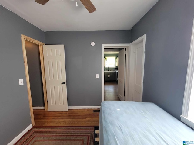 bedroom with hardwood / wood-style flooring, sink, and ceiling fan