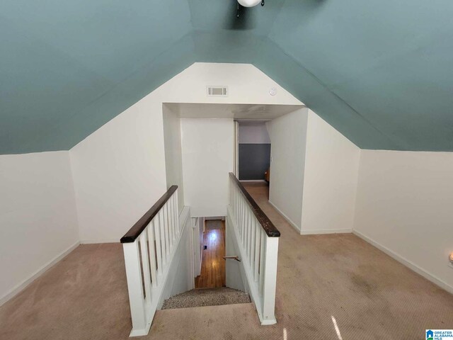 stairway with carpet floors and lofted ceiling