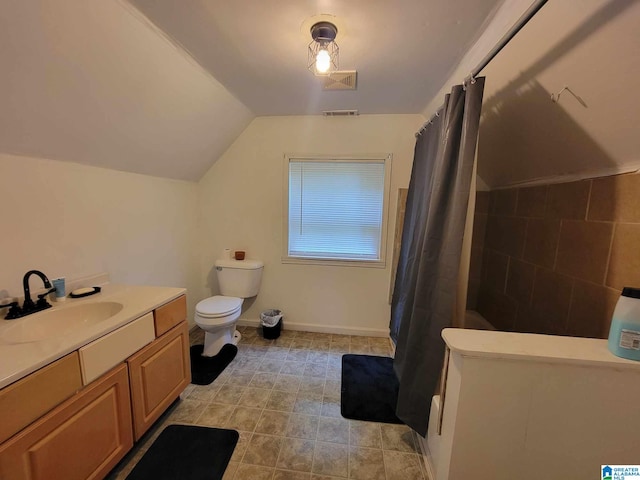 bathroom with tile patterned flooring, vanity, lofted ceiling, and toilet