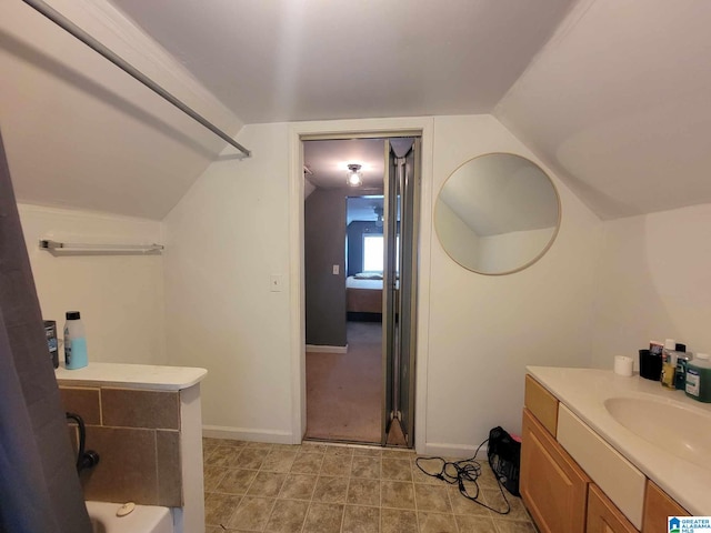 bathroom with tile patterned flooring, lofted ceiling, and vanity