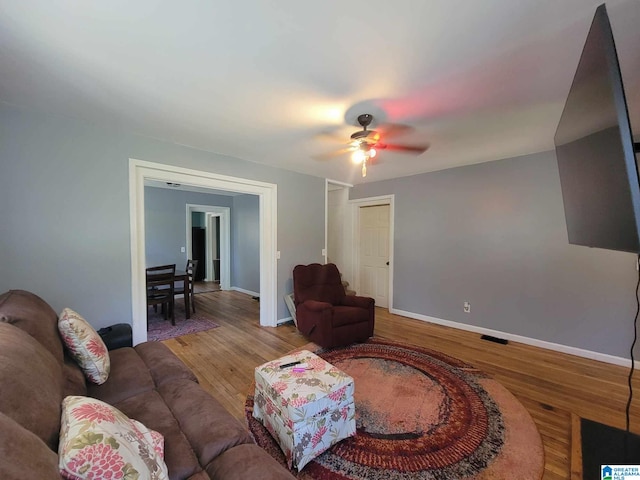 living room featuring ceiling fan and wood-type flooring