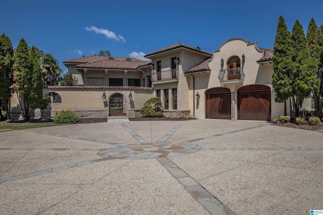 mediterranean / spanish-style home with a garage and a balcony