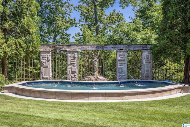 view of swimming pool with a yard