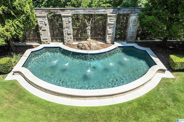 view of swimming pool featuring a yard