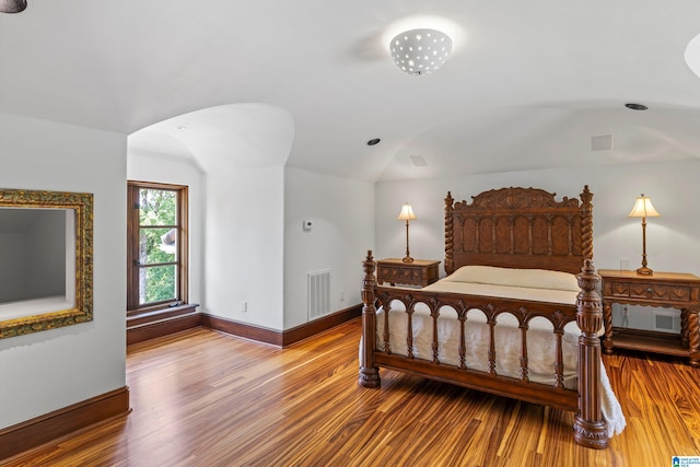 bedroom with lofted ceiling and wood-type flooring