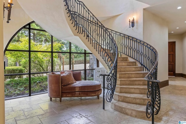 stairs featuring tile patterned flooring and a towering ceiling