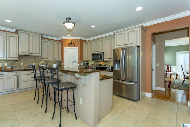 171 Sheeps Xing, Calera, AL 35040 - kitchen featuring light tile patterned floors, appliances with stainless steel finishes, dark countertops, a kitchen bar, and crown molding