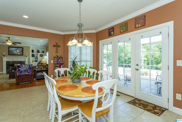 171 Sheeps Xing, Calera, AL 35040 - dining area featuring a high end fireplace, ceiling fan with notable chandelier, crown molding, french doors, and light tile patterned flooring