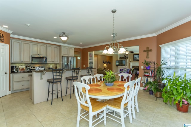 171 Sheeps Xing, Calera, AL 35040 - dining space with a fireplace, ceiling fan with notable chandelier, crown molding, and light tile patterned flooring