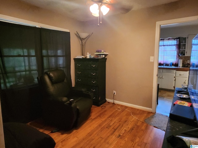 living area with hardwood / wood-style flooring and ceiling fan