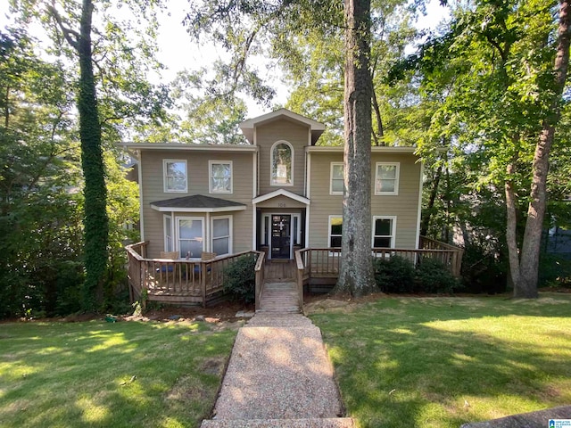 front of property with a wooden deck and a front lawn