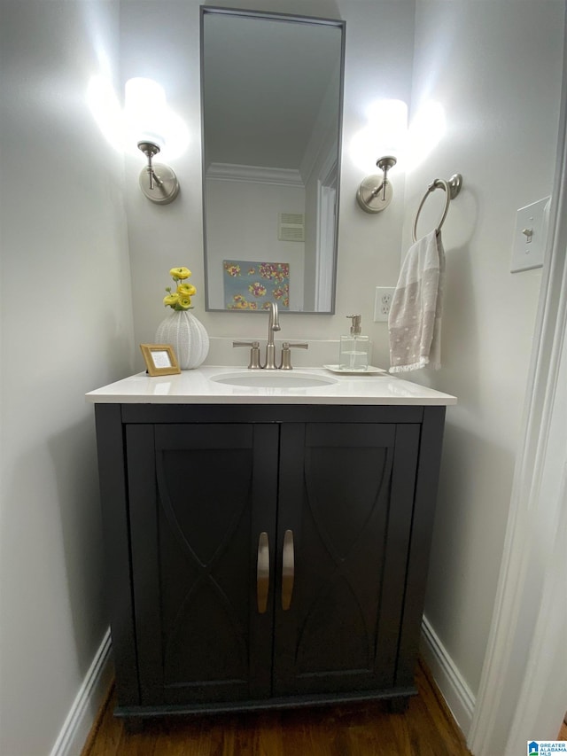 bathroom featuring vanity, ornamental molding, and wood-type flooring