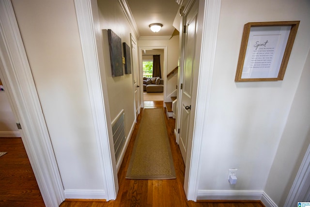 hallway featuring ornamental molding and hardwood / wood-style flooring