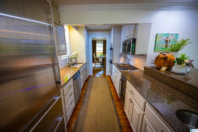 kitchen with white cabinets, sink, stainless steel appliances, and decorative backsplash