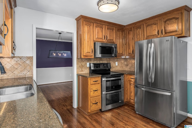 kitchen featuring dark wood-type flooring, stainless steel appliances, ornamental molding, and decorative backsplash