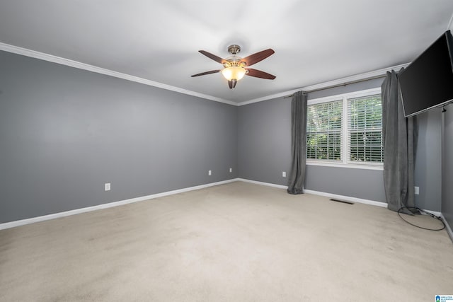 carpeted empty room with ceiling fan and crown molding