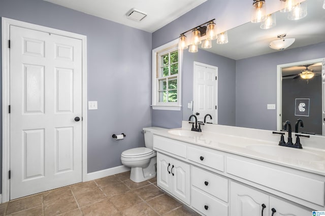 bathroom with toilet, double sink vanity, ceiling fan, and tile patterned flooring