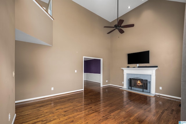 unfurnished living room with ceiling fan, high vaulted ceiling, and wood-type flooring