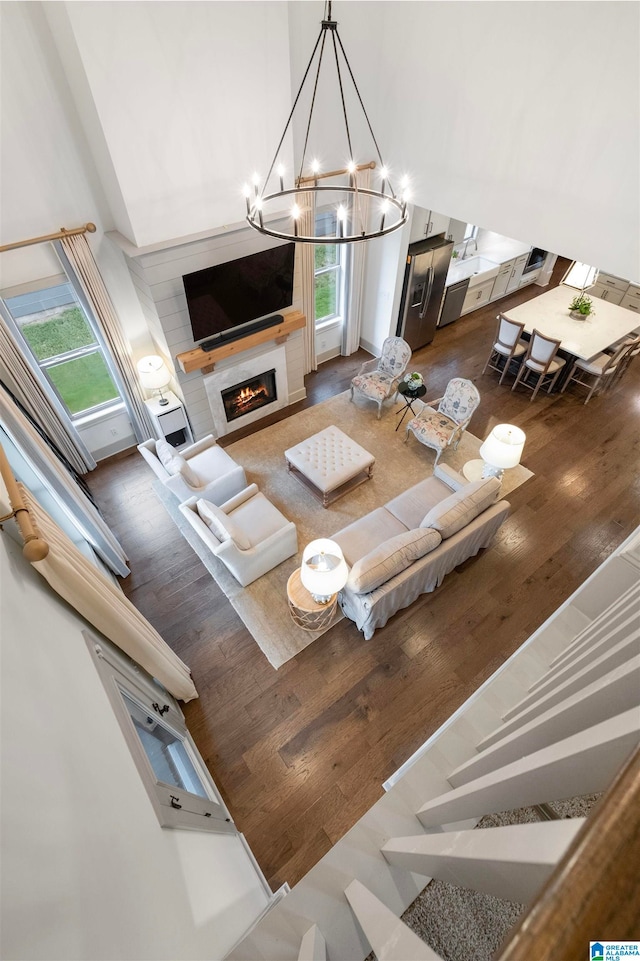 living room featuring a high ceiling, dark hardwood / wood-style flooring, and an inviting chandelier