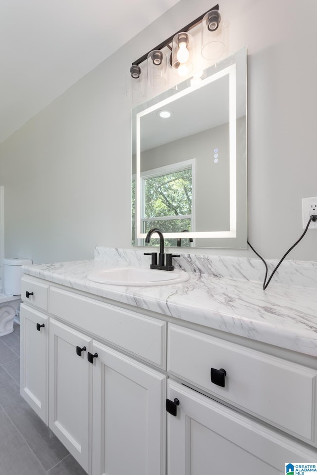 bathroom featuring tile patterned flooring, toilet, and vanity