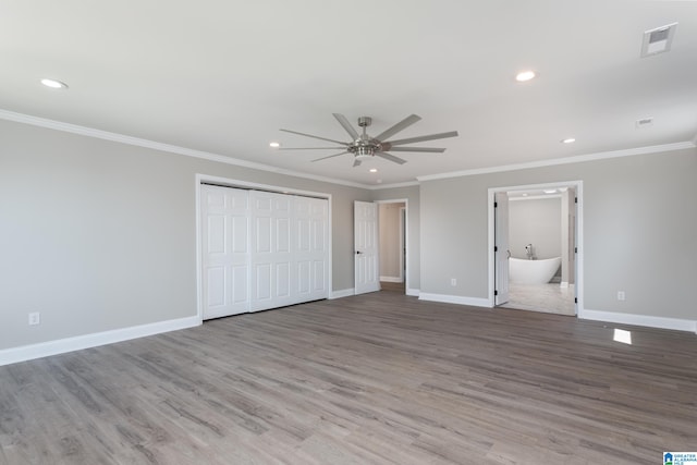 unfurnished bedroom featuring ceiling fan, ornamental molding, connected bathroom, and wood-type flooring