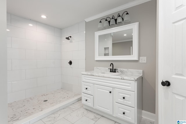 bathroom featuring tile patterned flooring, ornamental molding, a tile shower, and vanity