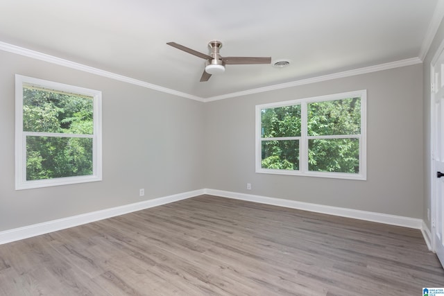 unfurnished room featuring ceiling fan, a wealth of natural light, hardwood / wood-style floors, and crown molding