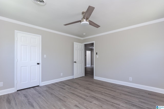 unfurnished bedroom featuring hardwood / wood-style floors, crown molding, and ceiling fan