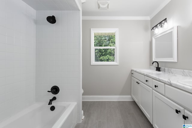 bathroom with crown molding, vanity, and tiled shower / bath combo