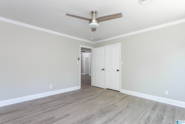 empty room featuring ceiling fan, light hardwood / wood-style floors, and crown molding