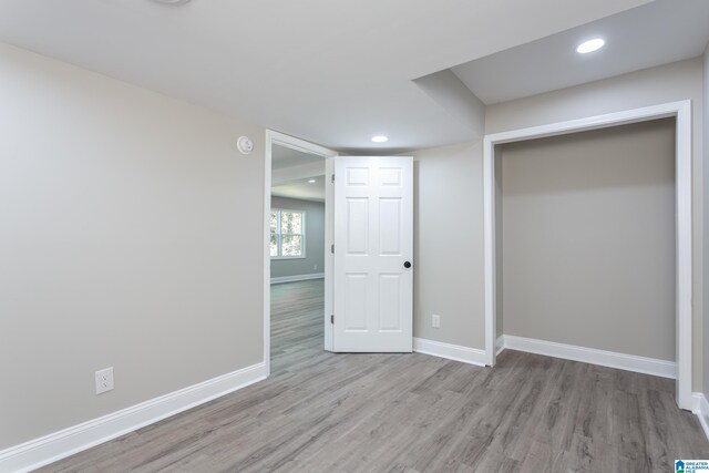 unfurnished bedroom with wood-type flooring and a closet